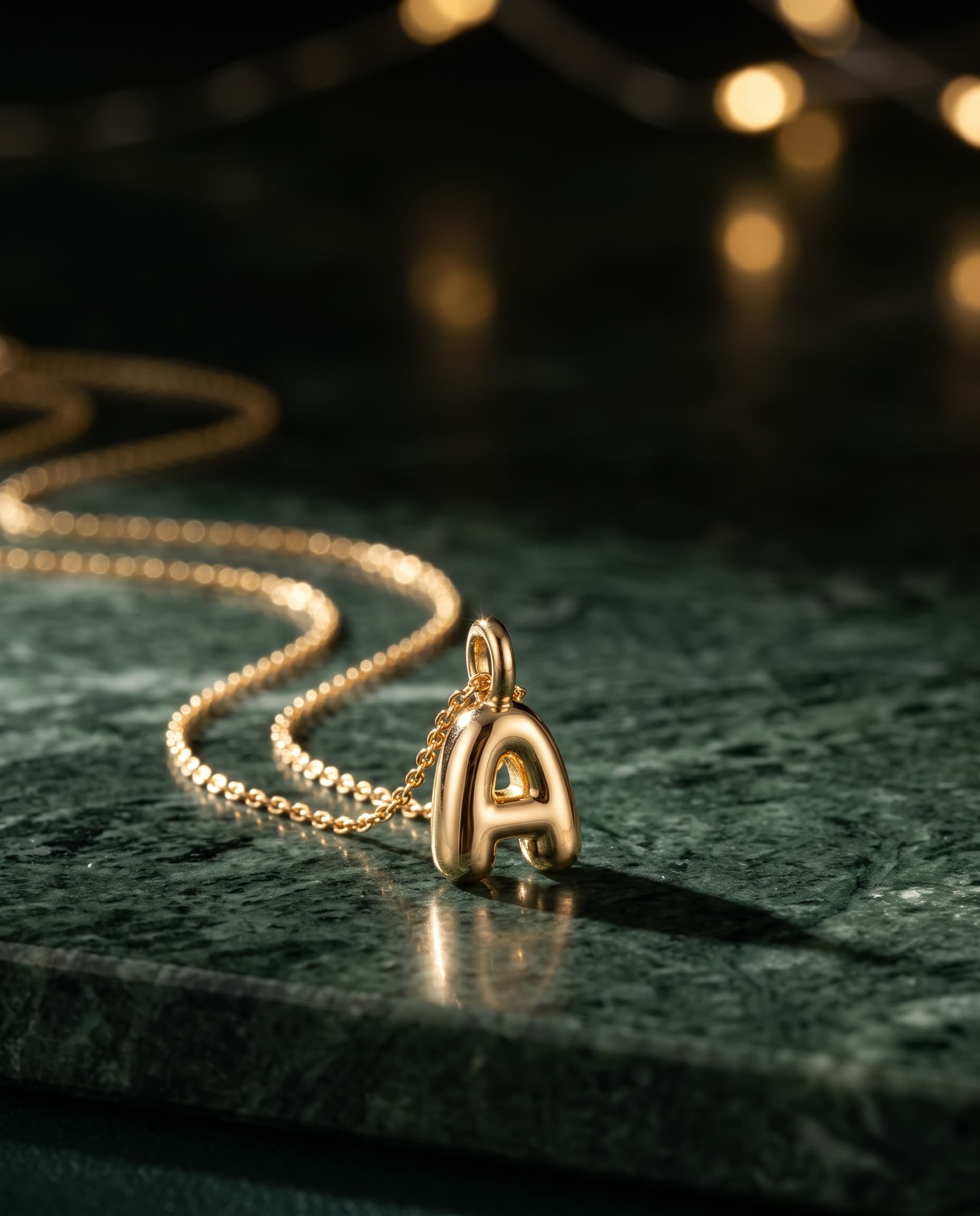 Gold initial pendant necklace on marble